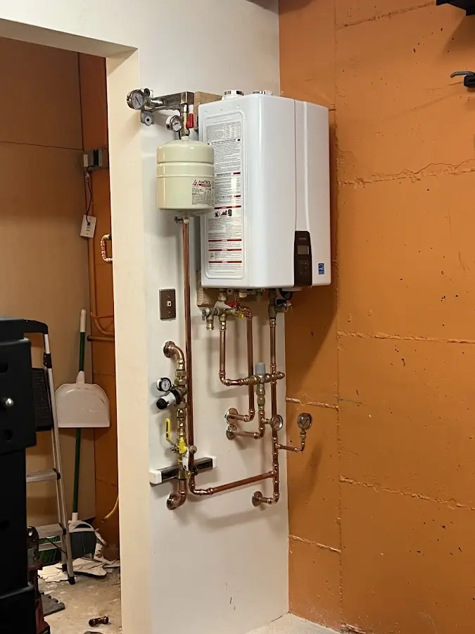 Plumbing technician inspecting water heater connections in Wailuku